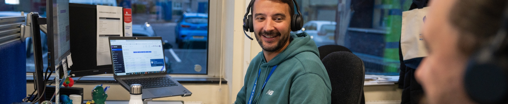 Man smiling in Customer Services with headset on